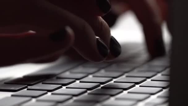 Mujer joven escribiendo en un teclado portátil — Vídeo de stock