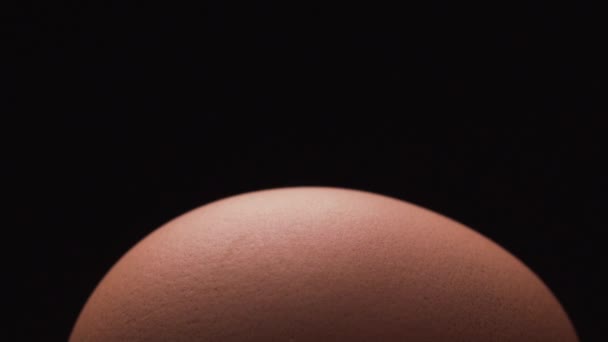 Нож трещит свежее яйцо на черном фоне — стоковое видео