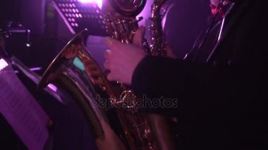 Müzisyen konserde saksafon üzerinde oynuyor.