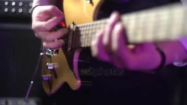 Konserde gitar çalmak.