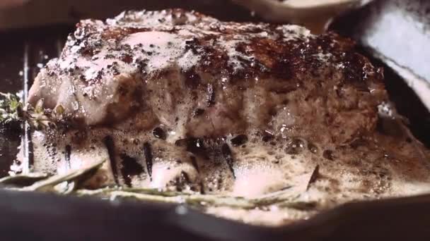 Vierte aceite sobre el bistec en una sartén — Vídeos de Stock