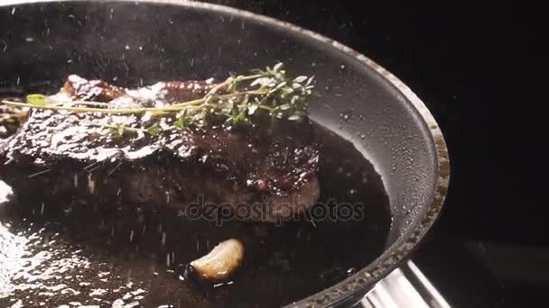 Menuangkan minyak ke steak dalam wajan. — Stok Video