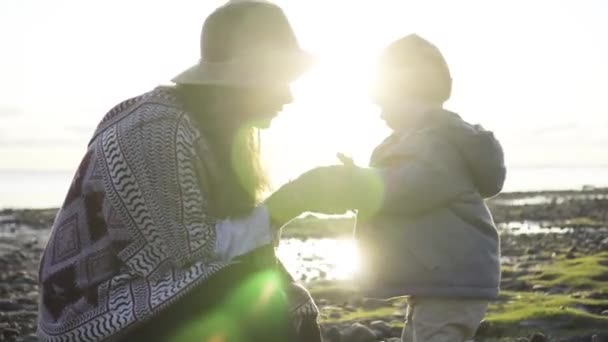 Mamma con un bambino cammina sulla spiaggia — Video Stock