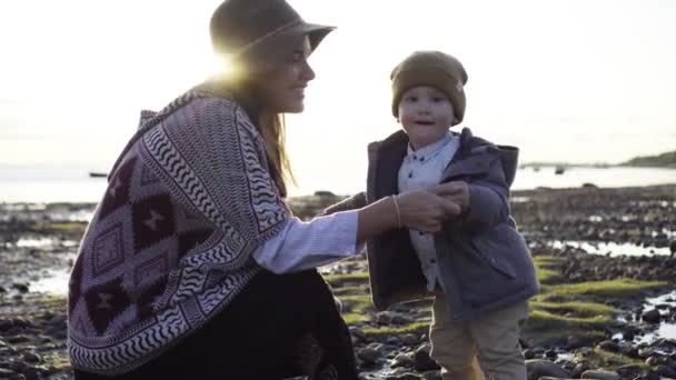 Mutter küsst ihren Sohn am Strand — Stockvideo