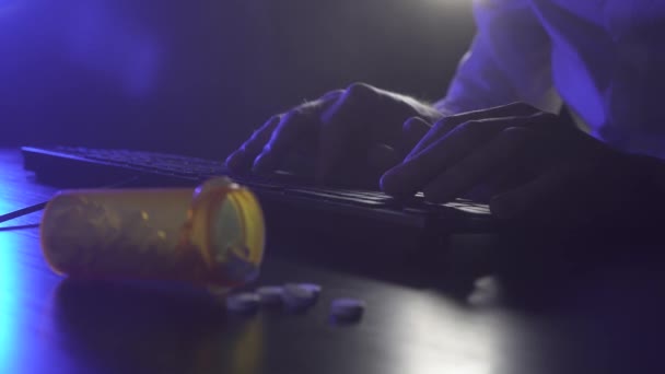 Man is typing on a keyboard. Pills in the foreground — Stock Video