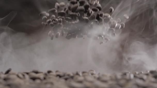 Кавові зерна лопаються і падають крізь дим — стокове відео