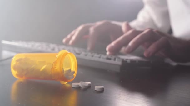 Man is typing on a keyboard. Pills in the foreground — Stock Video