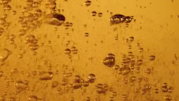 Il liquido arancione viene versato in un bicchiere. Molte bolle in aumento — Video Stock