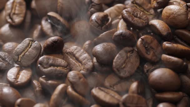 Los granos de café giran mientras se tuestan. El humo proviene de granos de café . — Vídeo de stock