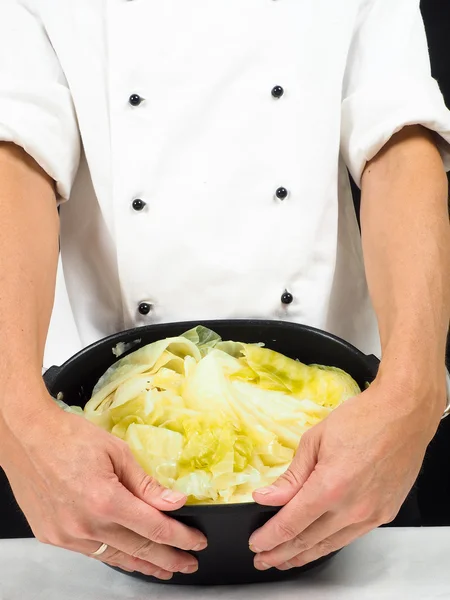 Chef en veste blanche tenant autour d'une casserole au chou — Photo