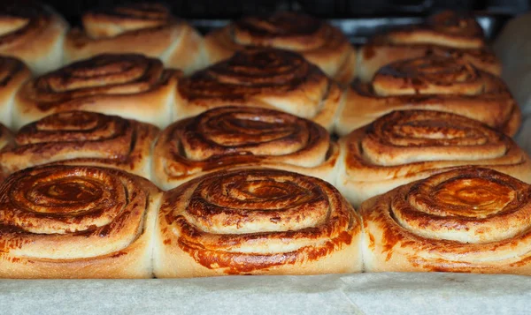 Primer plano de bollos de canela recién horneados después de hornear en el horno, con — Foto de Stock