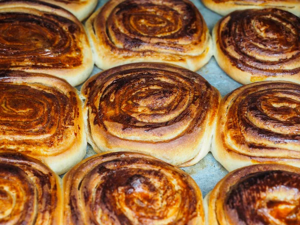 Primer plano de bollos de canela recién horneados después de hornear en el horno, con — Foto de Stock