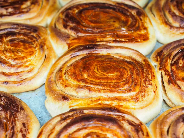 Primer plano de bollos de canela recién horneados después de hornear en el horno, con — Foto de Stock