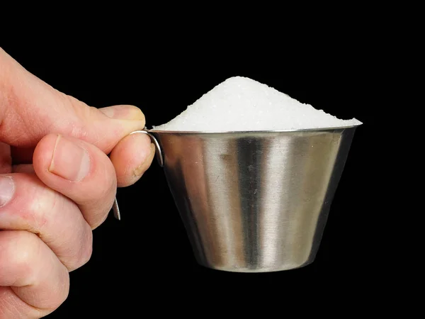 Person holding a measuring cup of one deciliter filled up with w Stock Image