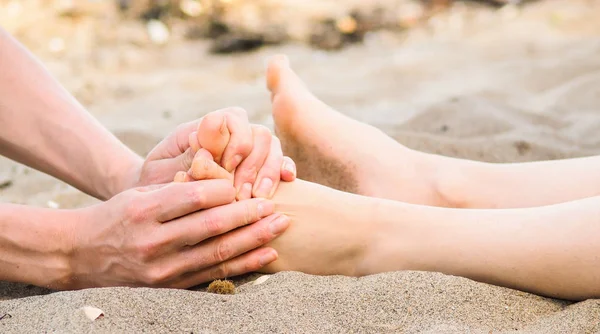 Foot massage on a beach in sand, male and female caucasian — Stock Photo, Image