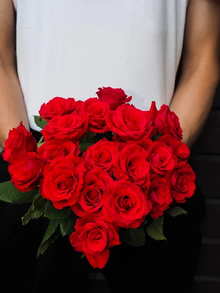 Hombre sosteniendo un hermoso ramo de rosas rojas usando whi Imágenes de stock libres de derechos