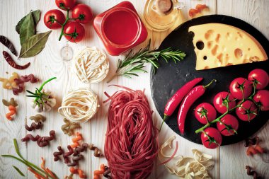 Makarna sebze ve eski bir arka plan üzerinde mutfak aksesuarları ile bir kompozisyon içinde