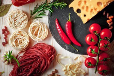 Makarna sebze ve eski bir arka plan üzerinde mutfak aksesuarları ile bir kompozisyon içinde