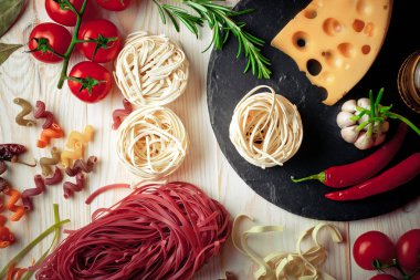 Makarna sebze ve eski bir arka plan üzerinde mutfak aksesuarları ile bir kompozisyon içinde