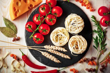 Makarna sebze ve eski bir arka plan üzerinde mutfak aksesuarları ile bir kompozisyon içinde