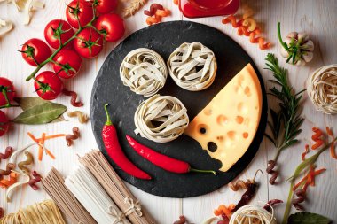 Makarna sebze ve eski bir arka plan üzerinde mutfak aksesuarları ile bir kompozisyon içinde