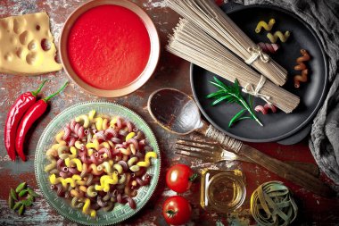 Makarna sebze ve eski bir arka plan üzerinde mutfak aksesuarları ile bir kompozisyon içinde