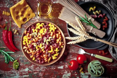 Makarna sebze ve eski bir arka plan üzerinde mutfak aksesuarları ile bir kompozisyon içinde