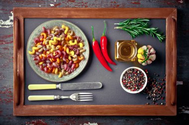 Makarna sebze ve eski bir arka plan üzerinde mutfak aksesuarları ile bir kompozisyon içinde