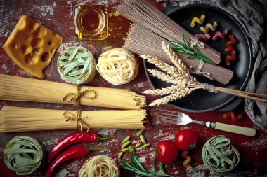 Makarna sebze ve eski bir arka plan üzerinde mutfak aksesuarları ile bir kompozisyon içinde