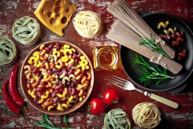 Makarna sebze ve eski bir arka plan üzerinde mutfak aksesuarları ile bir kompozisyon içinde