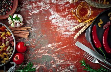 Makarna sebze ve eski bir arka plan üzerinde mutfak aksesuarları ile bir kompozisyon içinde