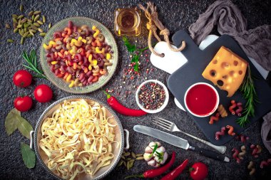 Makarna sebze ve eski bir arka plan üzerinde mutfak aksesuarları ile bir kompozisyon içinde