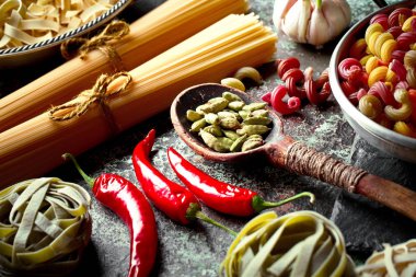 Makarna sebze ve eski bir arka plan üzerinde mutfak aksesuarları ile bir kompozisyon içinde