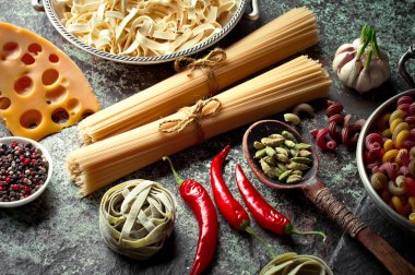 Makarna sebze ve eski bir arka plan üzerinde mutfak aksesuarları ile bir kompozisyon içinde