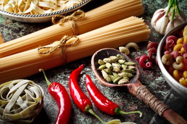 Makarna sebze ve eski bir arka plan üzerinde mutfak aksesuarları ile bir kompozisyon içinde