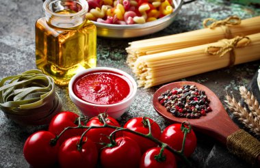 Makarna sebze ve eski bir arka plan üzerinde mutfak aksesuarları ile bir kompozisyon içinde