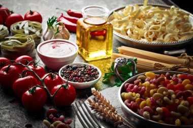 Makarna sebze ve eski bir arka plan üzerinde mutfak aksesuarları ile bir kompozisyon içinde