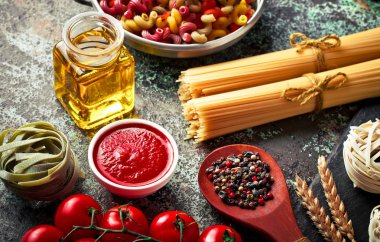 Makarna sebze ve eski bir arka plan üzerinde mutfak aksesuarları ile bir kompozisyon içinde