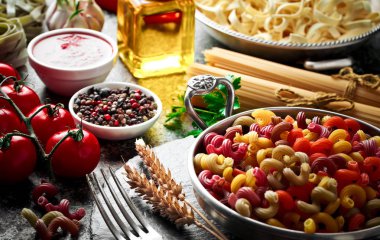 Makarna sebze ve eski bir arka plan üzerinde mutfak aksesuarları ile bir kompozisyon içinde