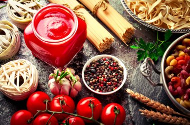 Makarna sebze ve eski bir arka plan üzerinde mutfak aksesuarları ile bir kompozisyon içinde