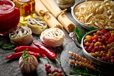 Makarna sebze ve eski bir arka plan üzerinde mutfak aksesuarları ile bir kompozisyon içinde