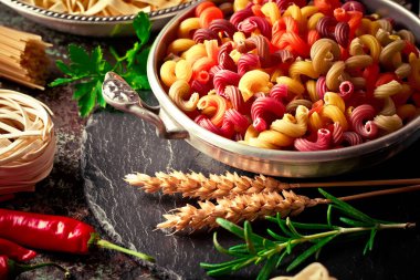 Makarna sebze ve eski bir arka plan üzerinde mutfak aksesuarları ile bir kompozisyon içinde