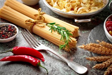 Makarna sebze ve eski bir arka plan üzerinde mutfak aksesuarları ile bir kompozisyon içinde