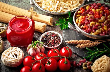 Makarna sebze ve eski bir arka plan üzerinde mutfak aksesuarları ile bir kompozisyon içinde