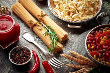 Makarna sebze ve eski bir arka plan üzerinde mutfak aksesuarları ile bir kompozisyon içinde