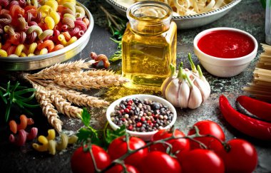 Makarna sebze ve eski bir arka plan üzerinde mutfak aksesuarları ile bir kompozisyon içinde