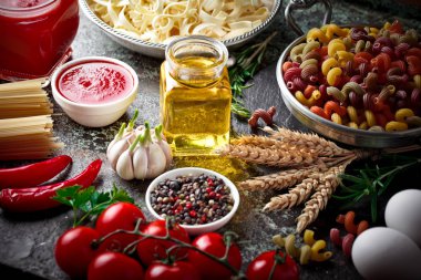 Makarna sebze ve eski bir arka plan üzerinde mutfak aksesuarları ile bir kompozisyon içinde