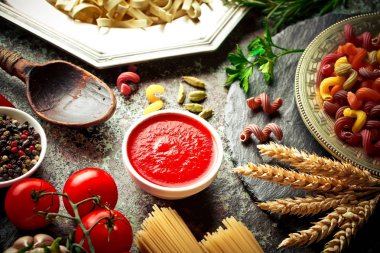 Makarna sebze ve eski bir arka plan üzerinde mutfak aksesuarları ile bir kompozisyon içinde