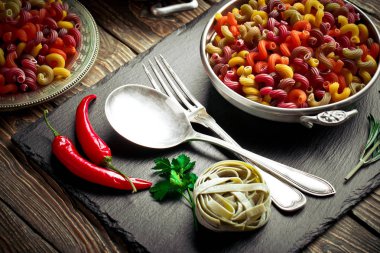 Makarna sebze ve eski bir arka plan üzerinde mutfak aksesuarları ile bir kompozisyon içinde