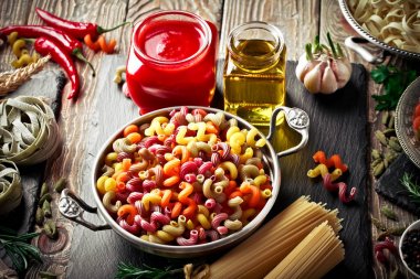 Makarna sebze ve eski bir arka plan üzerinde mutfak aksesuarları ile bir kompozisyon içinde